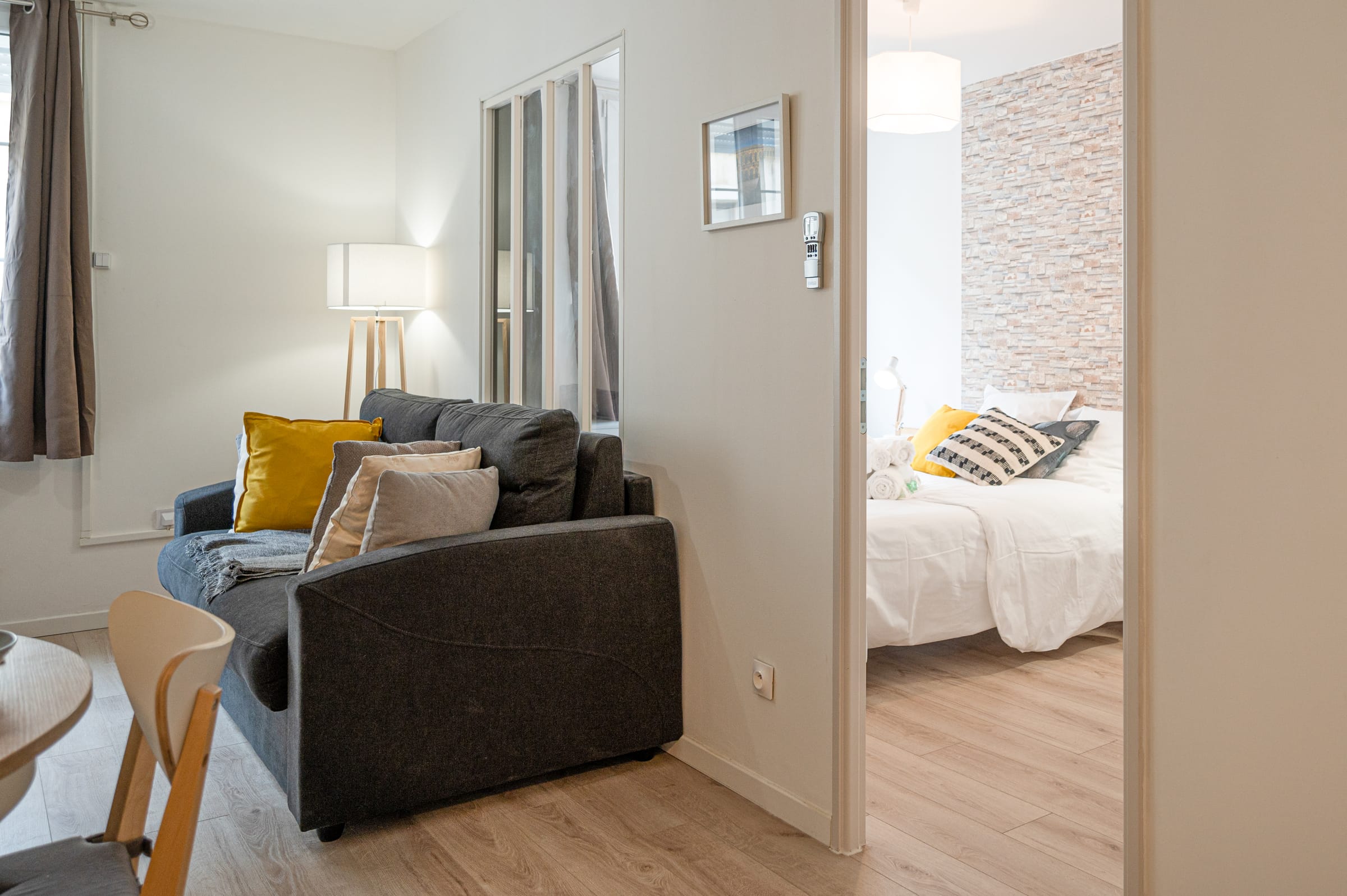 Salon avec vue sur la chambre par la porte ouverte, appartement La Balade Nîmoise